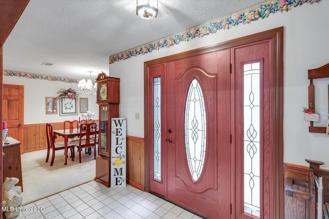 entrance foyer with plenty of natural light, a textured ceiling, and a notable chandelier