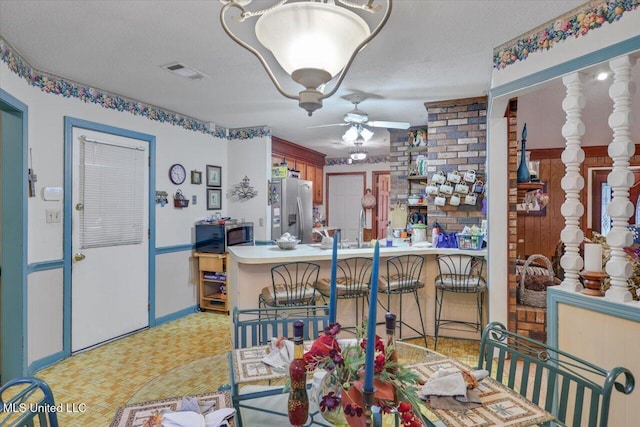 dining space with a textured ceiling, ceiling fan, and sink