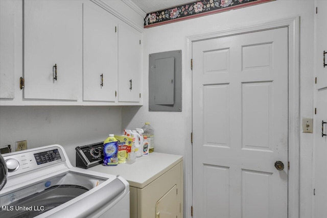 washroom featuring electric panel, washer and clothes dryer, cabinets, and a textured ceiling