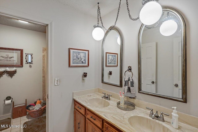 bathroom featuring tile patterned floors, vanity, and a textured ceiling