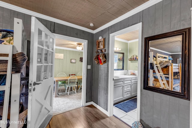 interior space featuring wood finished floors, baseboards, and ornamental molding