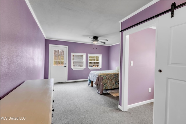 bedroom with baseboards, crown molding, a barn door, and carpet floors