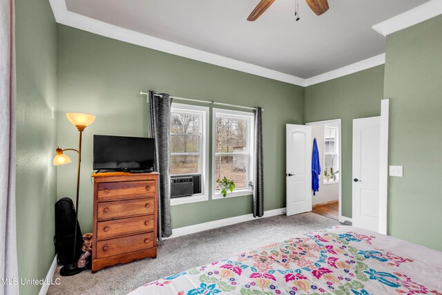 carpeted bedroom with ceiling fan, baseboards, and ornamental molding