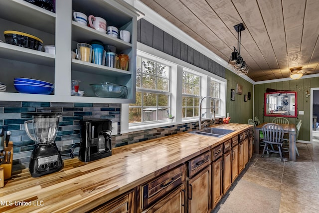 interior space featuring a sink, ornamental molding, wood ceiling, pendant lighting, and wood counters