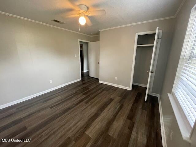 unfurnished bedroom featuring dark hardwood / wood-style flooring, a closet, ceiling fan, and ornamental molding