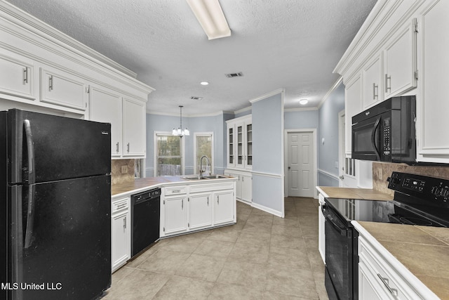 kitchen featuring sink, backsplash, pendant lighting, a chandelier, and black appliances