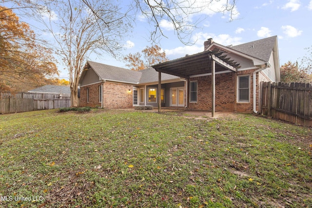 rear view of property featuring a lawn