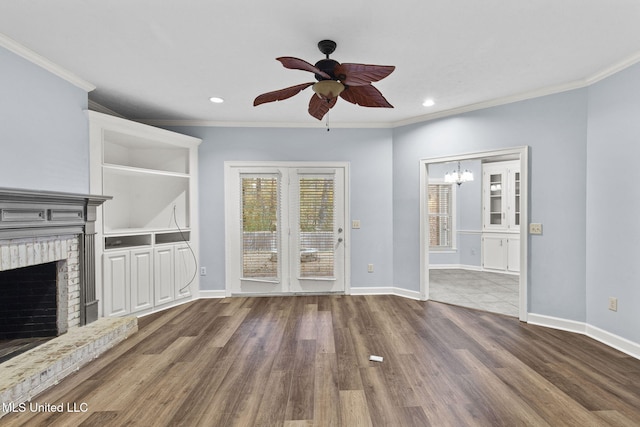 unfurnished living room with hardwood / wood-style floors, ornamental molding, and a brick fireplace