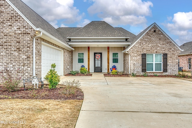 view of front of home featuring a garage, concrete driveway, brick siding, and board and batten siding