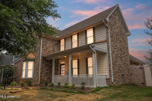 view of front of home featuring a porch and a lawn