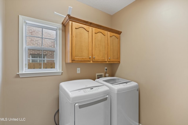 washroom featuring washing machine and dryer and cabinets