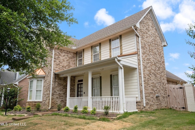 view of front facade with covered porch and a front yard