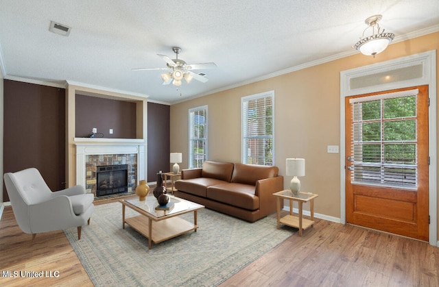 living room featuring plenty of natural light, ornamental molding, a textured ceiling, and wood-type flooring