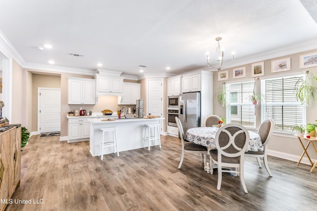 127 Grande View Dr, Biloxi, MS 39531 - dining area featuring visible vents, light wood finished floors, baseboards, ornamental molding, and an inviting chandelier