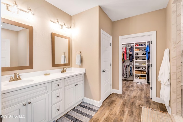 127 Grande View Dr, Biloxi, MS 39531 - bathroom with double vanity, a sink, a spacious closet, and wood finished floors
