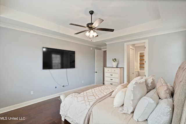 bedroom featuring a tray ceiling, ceiling fan, dark wood-type flooring, and ornamental molding