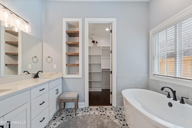 bathroom with tile patterned floors, vanity, a bathing tub, and built in features