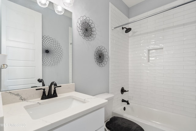 full bathroom featuring tiled shower / bath combo, toilet, and vanity