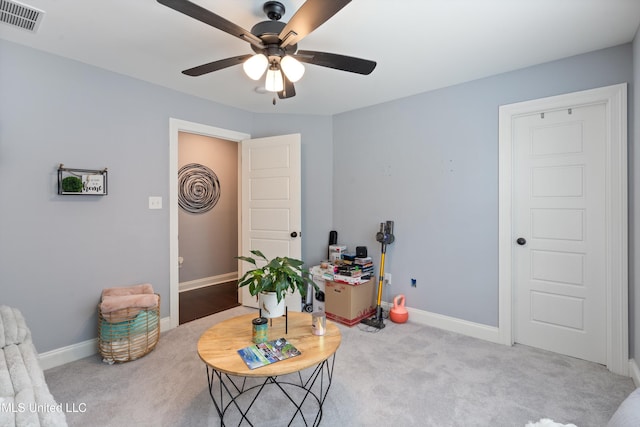 interior space with ceiling fan and light colored carpet