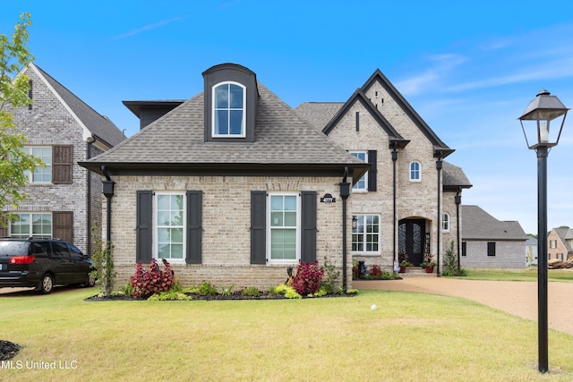 french country inspired facade with a front lawn