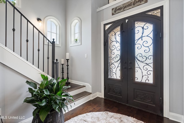 foyer entrance with french doors and dark hardwood / wood-style flooring