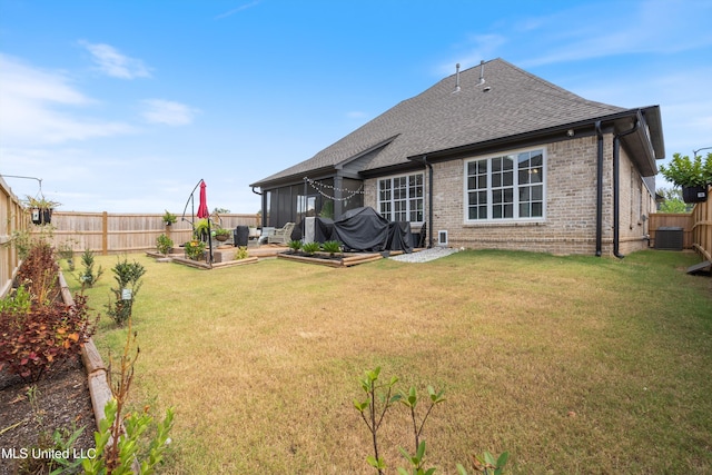 back of house with central AC unit, a patio area, and a yard