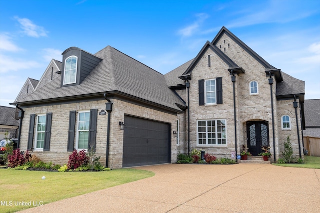 french country home featuring a garage and a front lawn