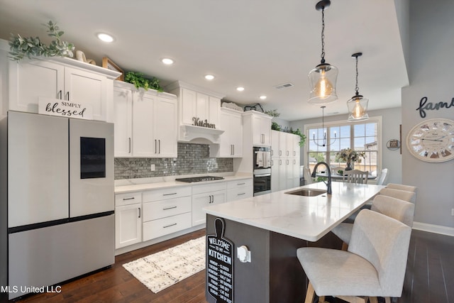 kitchen featuring stainless steel refrigerator, sink, dark hardwood / wood-style flooring, an island with sink, and white cabinets