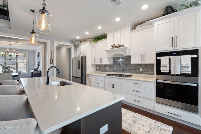 kitchen featuring sink, decorative light fixtures, a spacious island, and stainless steel appliances