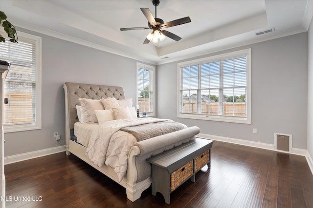 bedroom featuring dark hardwood / wood-style flooring, a tray ceiling, ceiling fan, and crown molding