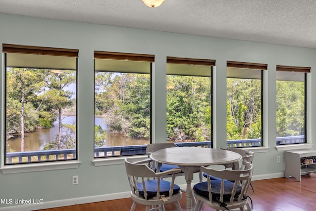 2529 Windward Dr, Gautier, MS 39553 - dining space with a water view, wood finished floors, a textured ceiling, and baseboards