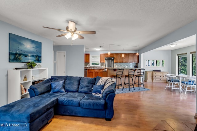 2529 Windward Dr, Gautier, MS 39553 - living room featuring light wood-type flooring, a textured ceiling, and a ceiling fan