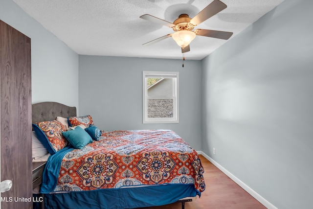 2529 Windward Dr, Gautier, MS 39553 - bedroom with wood finished floors, baseboards, a textured ceiling, and a ceiling fan