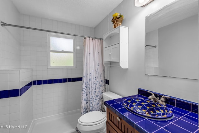 2529 Windward Dr, Gautier, MS 39553 - bathroom featuring toilet, vanity, a tile shower, and a textured ceiling
