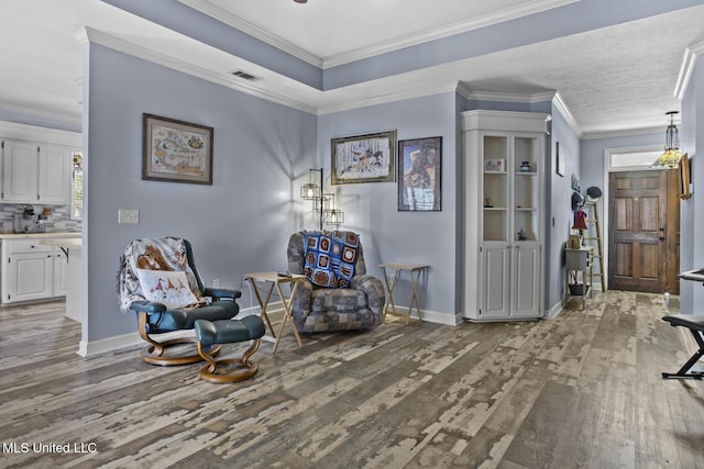 living area featuring crown molding and hardwood / wood-style floors