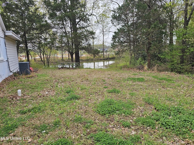 view of yard featuring central AC unit and a water view
