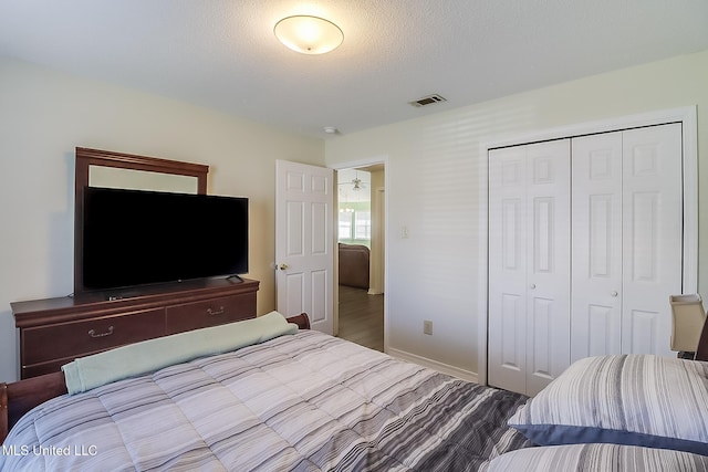 bedroom with a textured ceiling and a closet