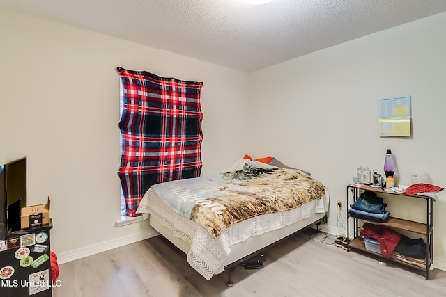 bedroom featuring a textured ceiling and hardwood / wood-style floors