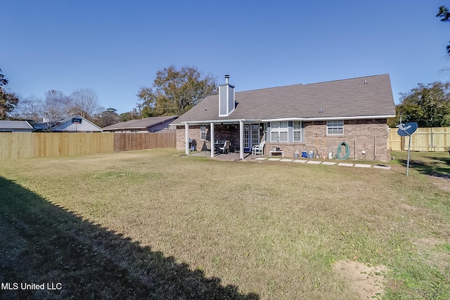 back of property featuring a lawn and a patio