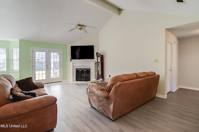 living room with a fireplace, vaulted ceiling with beams, light hardwood / wood-style floors, and french doors