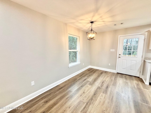 interior space with a notable chandelier and light hardwood / wood-style floors