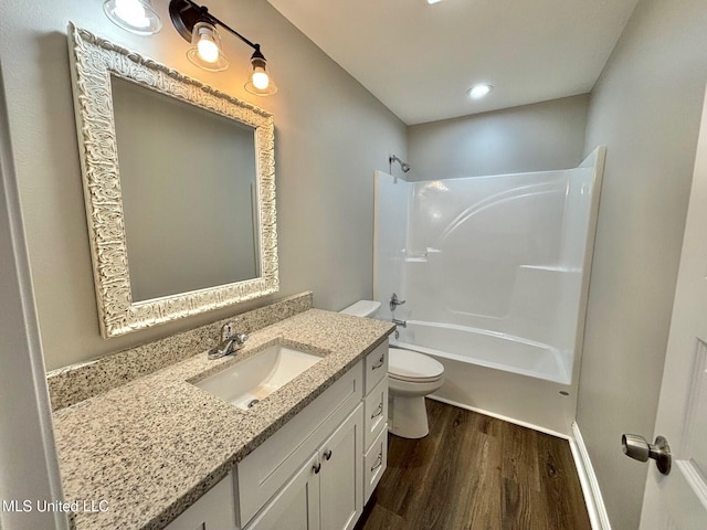 full bathroom featuring bathing tub / shower combination, hardwood / wood-style floors, vanity, and toilet