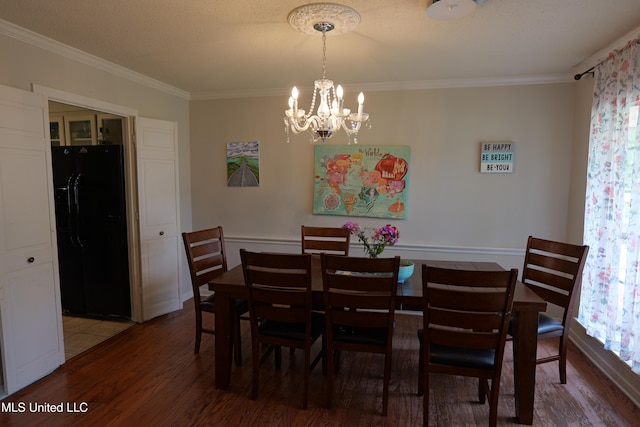 dining room with ornamental molding, wood finished floors, and a chandelier