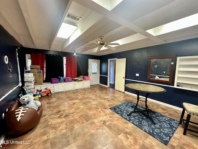 living area featuring visible vents, a ceiling fan, baseboards, and beamed ceiling