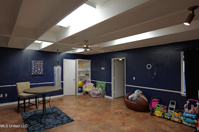 playroom with ceiling fan and baseboards