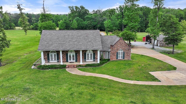 view of front of home featuring brick siding, a front yard, covered porch, and french doors