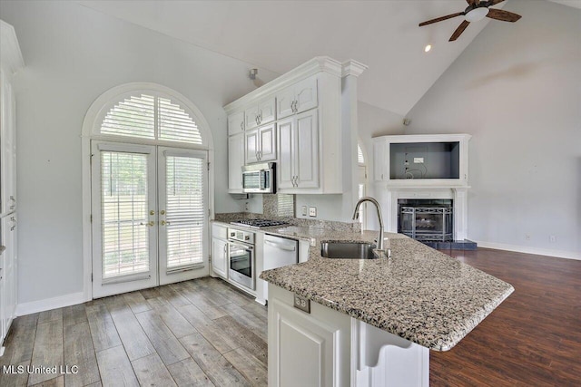 kitchen with stainless steel appliances, french doors, a sink, white cabinetry, and ceiling fan