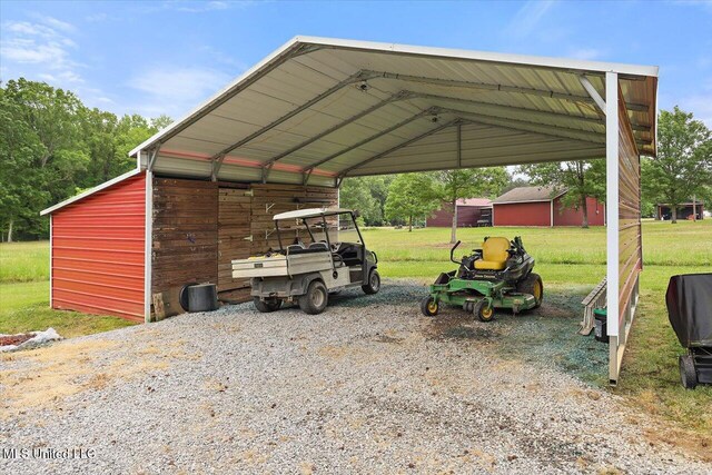 view of vehicle parking with gravel driveway and a carport