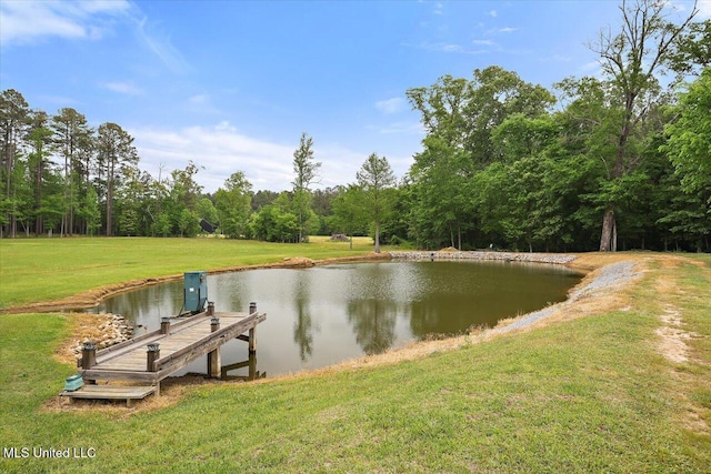 dock area featuring a lawn, a forest view, and a water view