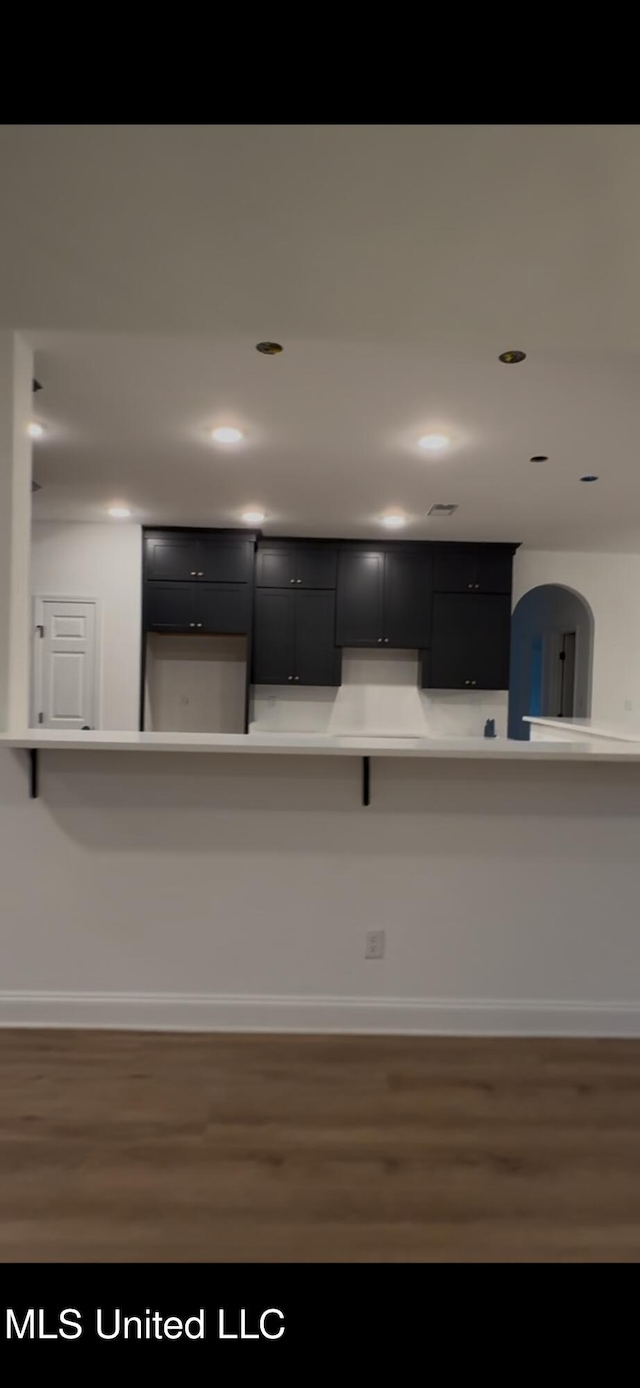 kitchen with dark wood-type flooring and a kitchen breakfast bar
